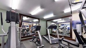 A gym with various exercise equipment, including treadmills and weight machines, and mirrors on the walls. - Hampton Inn & Suites By Hilton Calgary- University Northwest (Calgary)