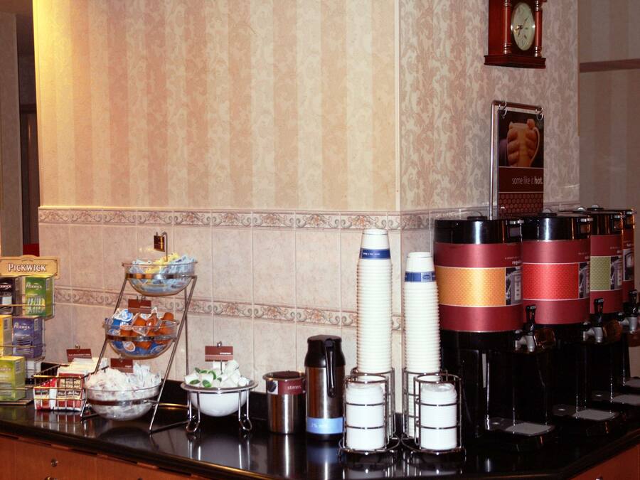 Montaje de bufé con diversas opciones de comida y dispensadores de bebidas.