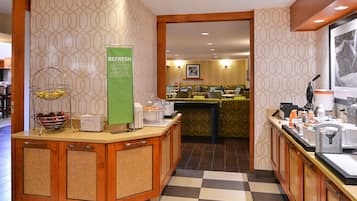 A hotel lobby with a buffet counter, a reception area, and a check-in desk.