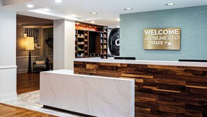 A reception area with a marble reception desk, a wooden accent wall, and a welcome sign. - Hampton Inn & Suites Charleston/West Ashley (Charleston)