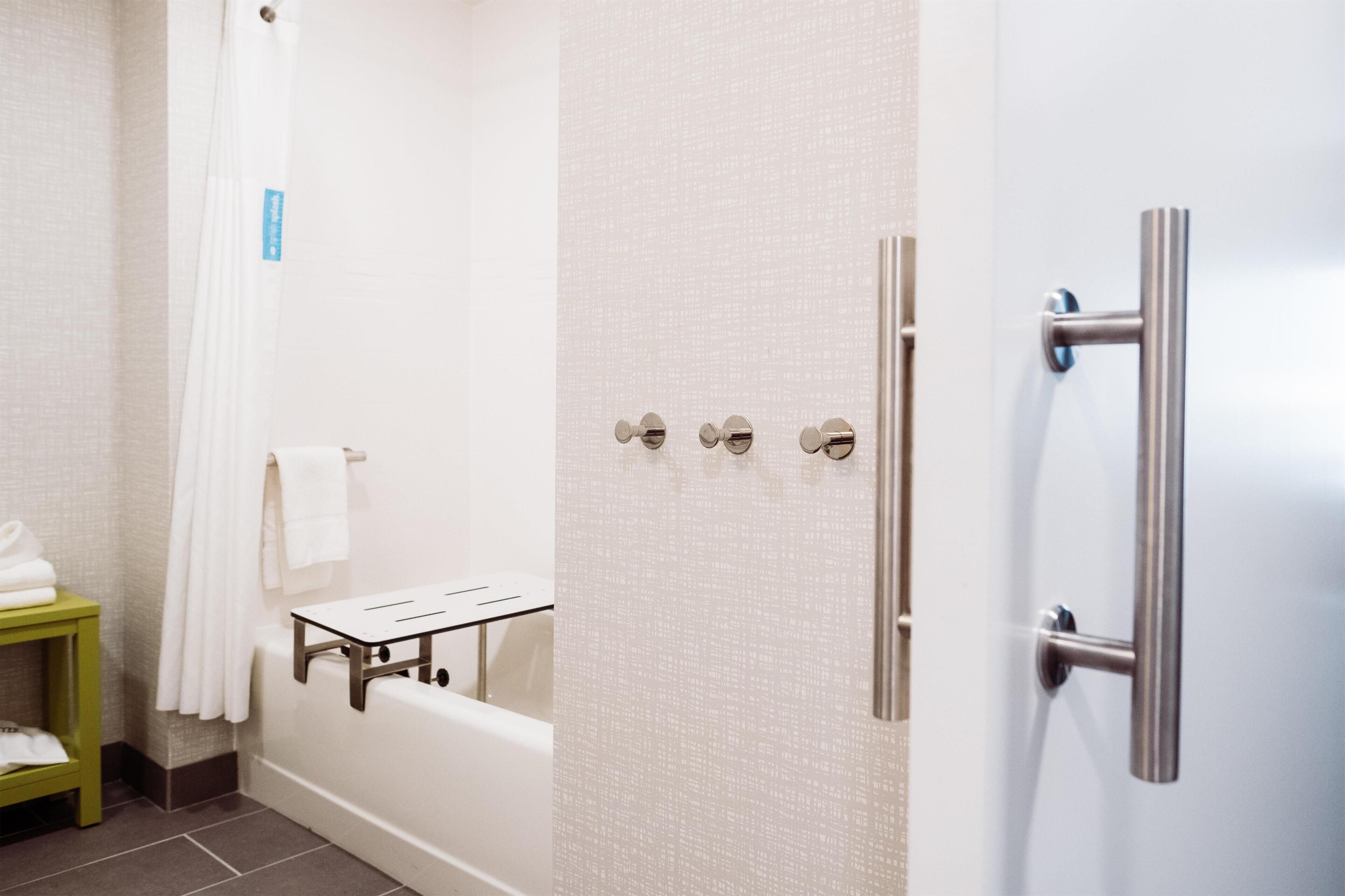 Un baño con bañera, zona de ducha y un perchero para toallas.