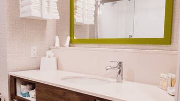 Un baño moderno con un lavabo blanco, un espejo con marco verde y un perchero sobre el lavabo.