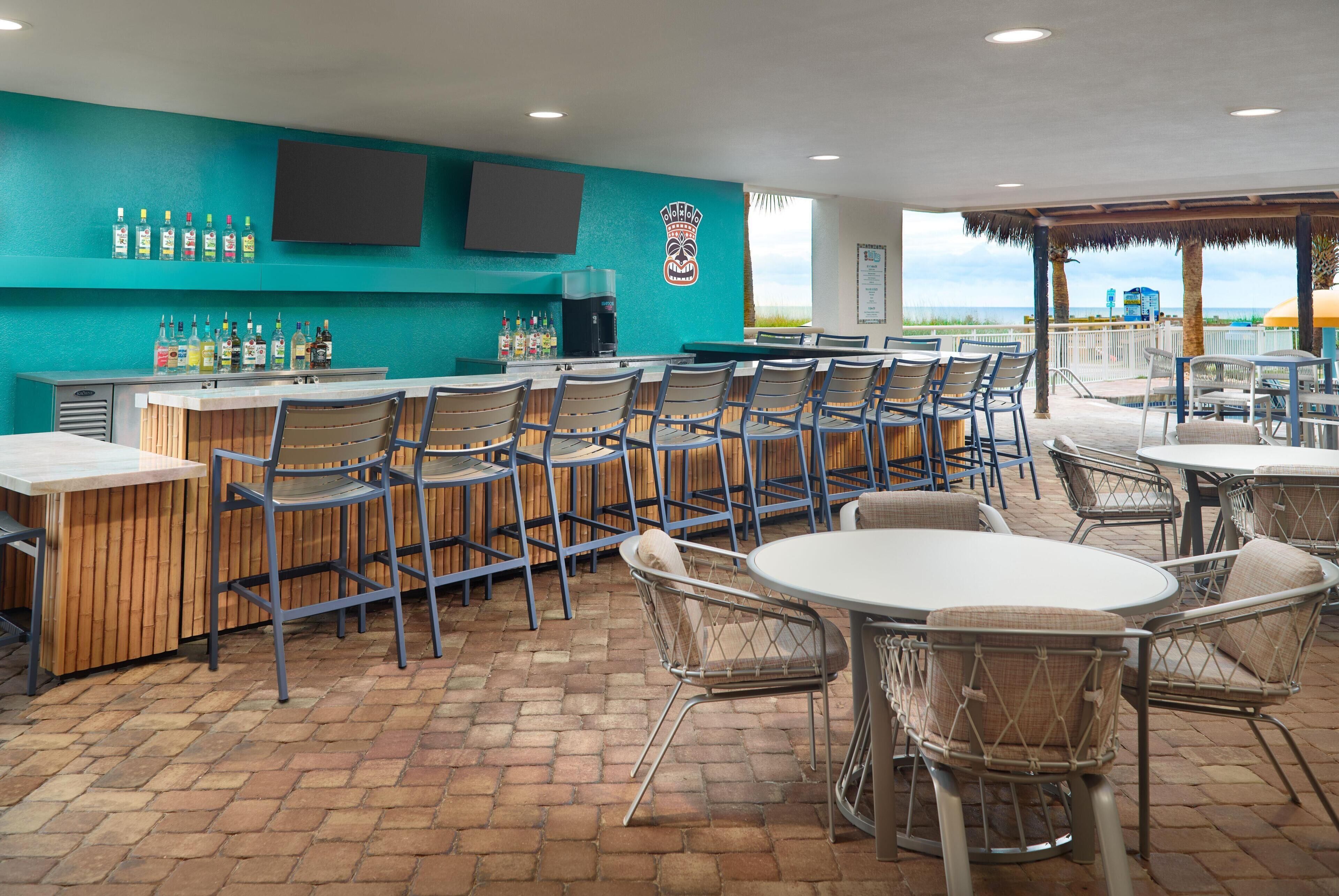 A bar area with a counter, chairs, and a TV mounted on the wall.