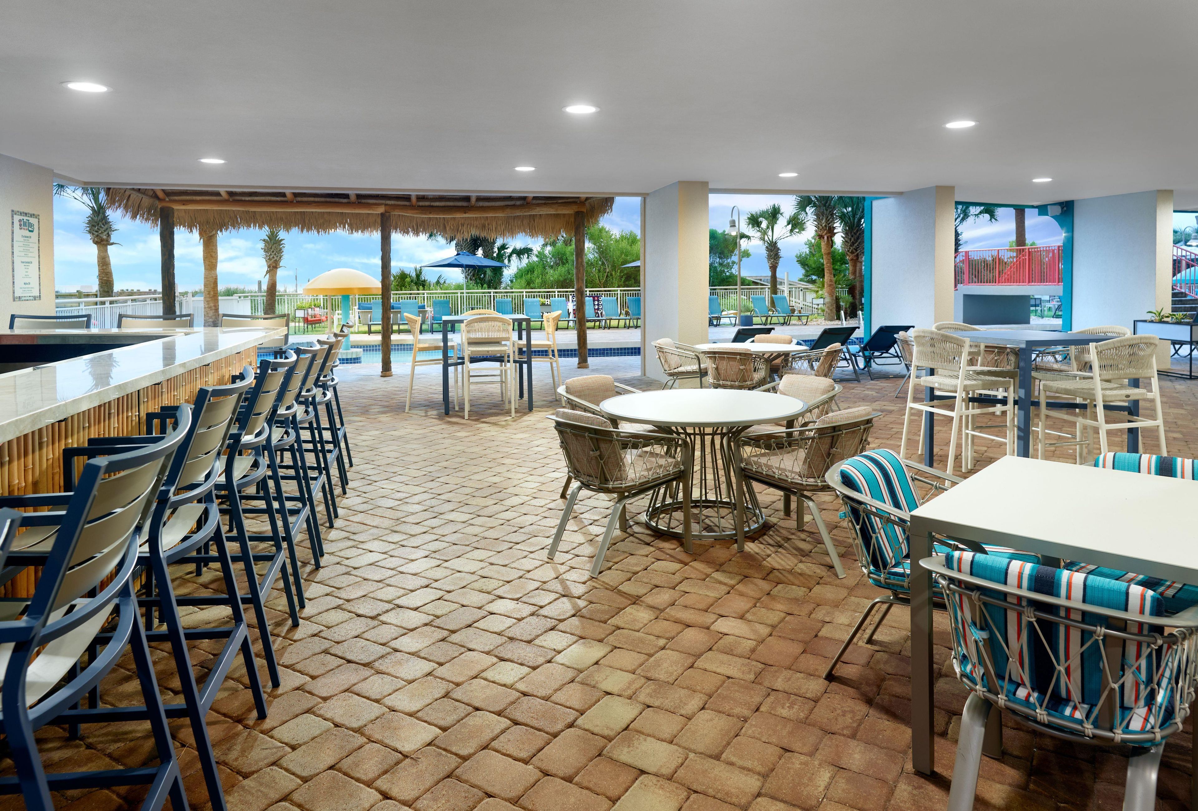 A bar area with seating, a pool view, and a covered patio.