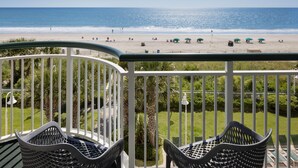 A balcony with a view of the beach, outdoor seating, and a railing. - Hampton Inn & Suites Myrtle Beach/Oceanfront (Myrtle Beach)