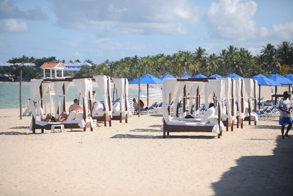 Am Strand, weißer Sandstrand, Liegestühle, Sonnenschirme