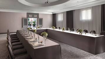 A conference room with a long table, chairs, and a staircase.