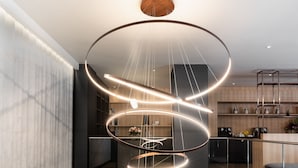 A modern interior with a spiral staircase, a minimalist kitchen, and a contemporary light fixture. - Crowne Plaza Geneva by IHG (Meyrin)