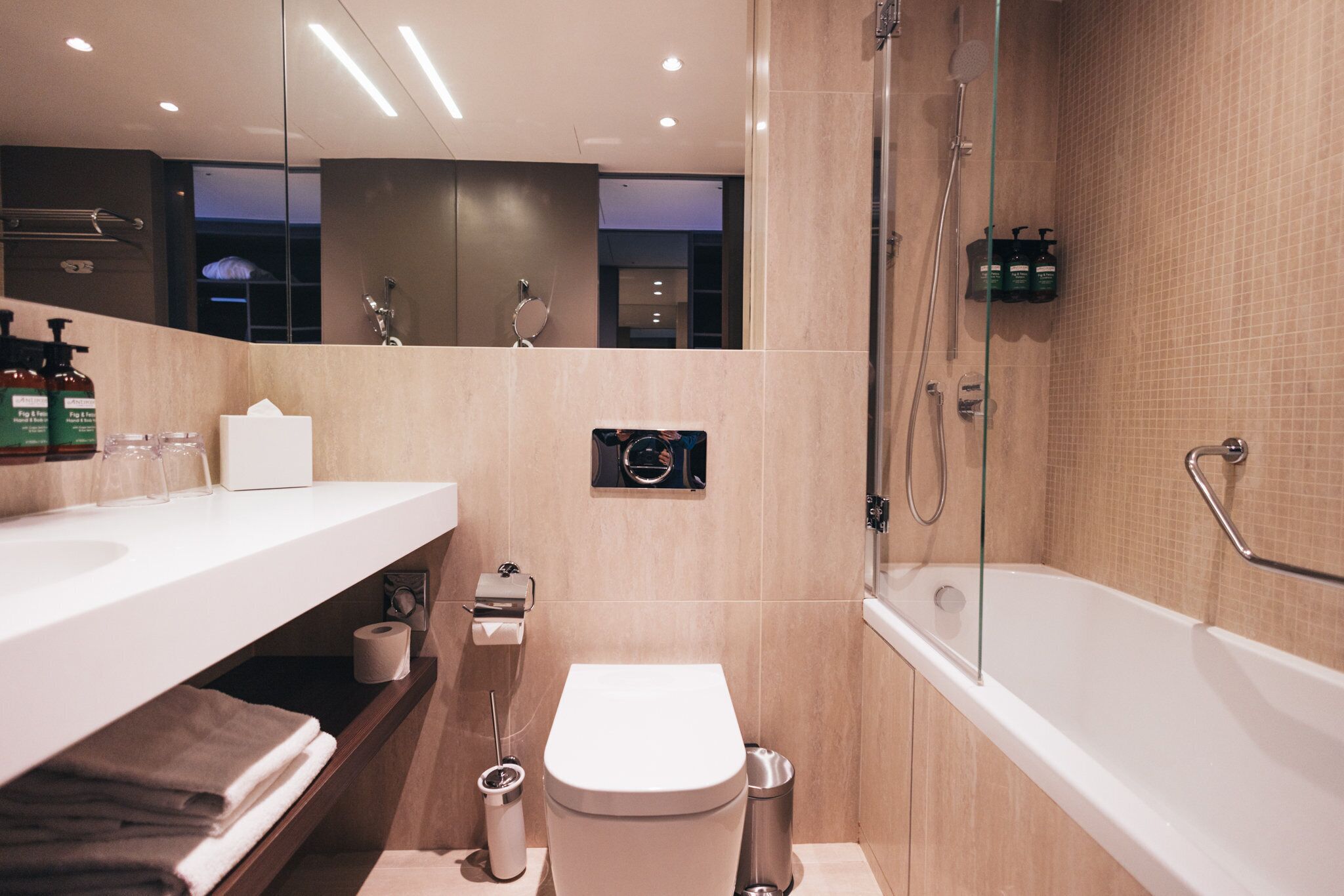 A modern bathroom with a toilet, bidet, and bathtub.
