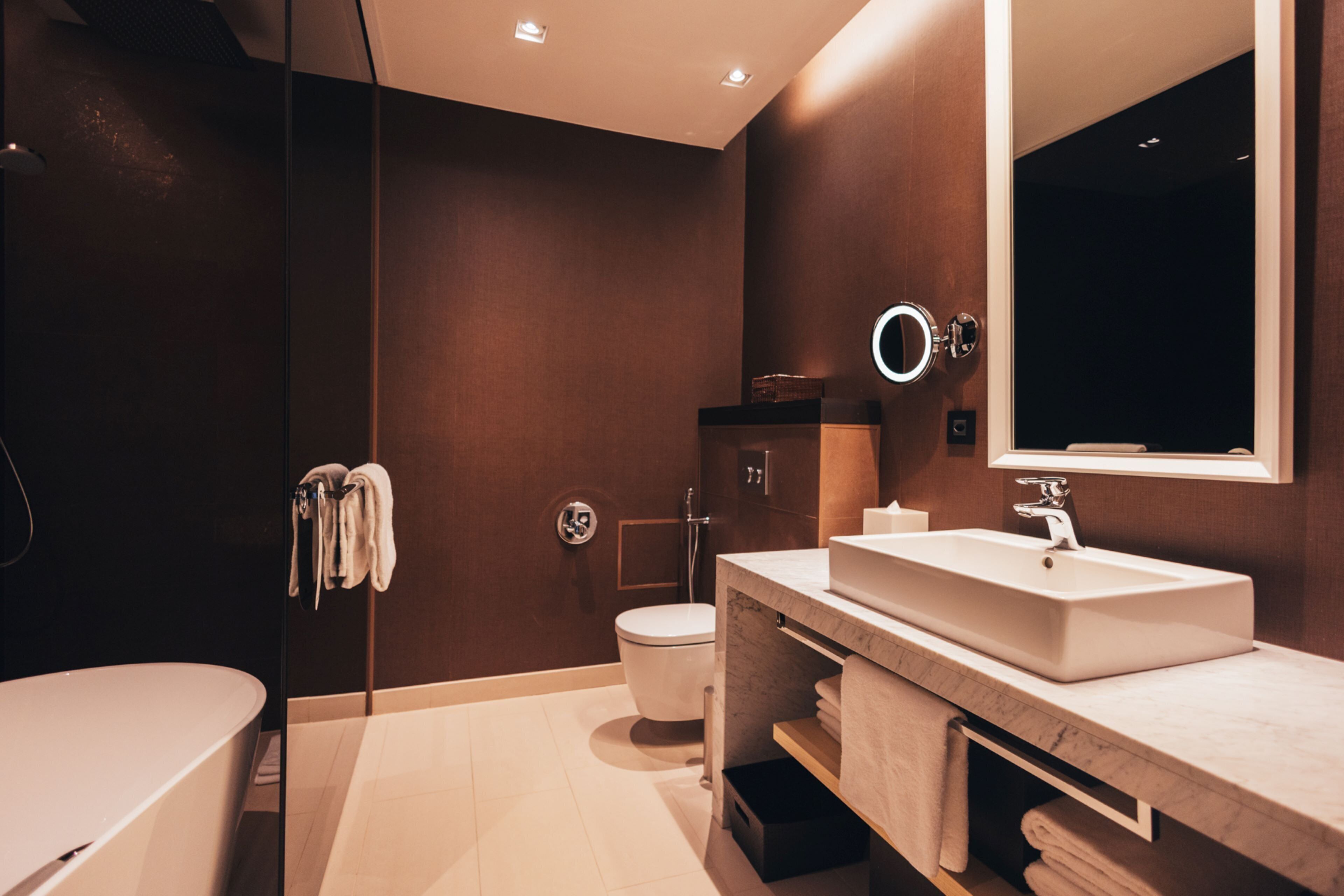 A modern bathroom with a bathtub, a sink, and a toilet.