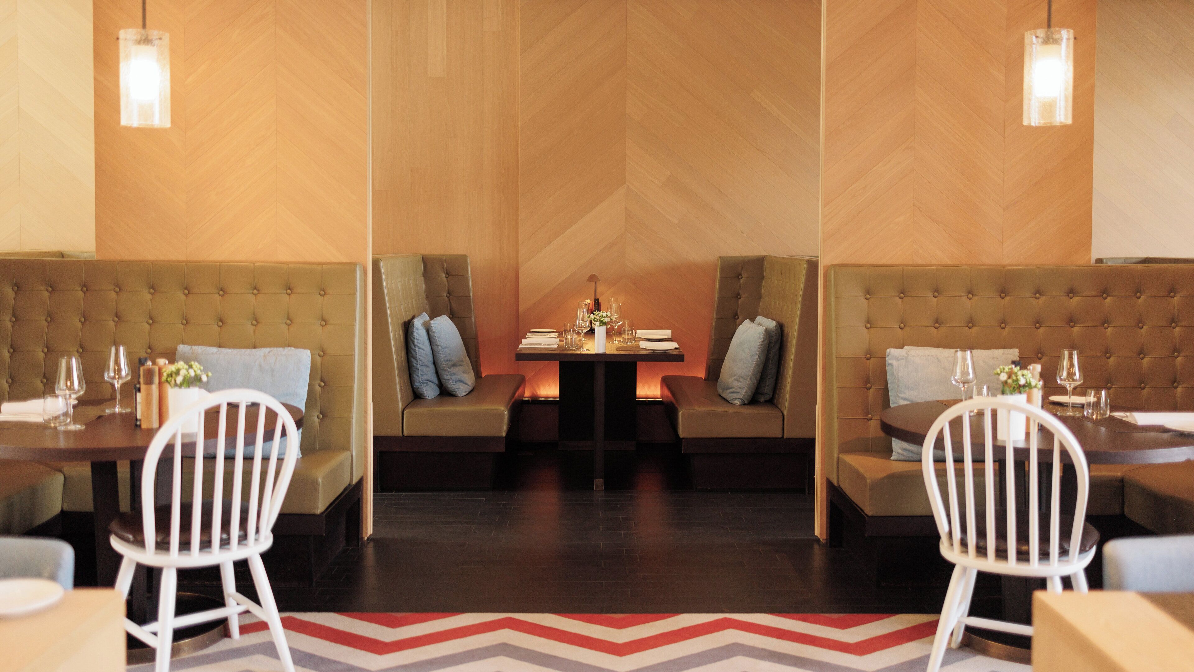 A dining area with two booths, a central table, and chairs.