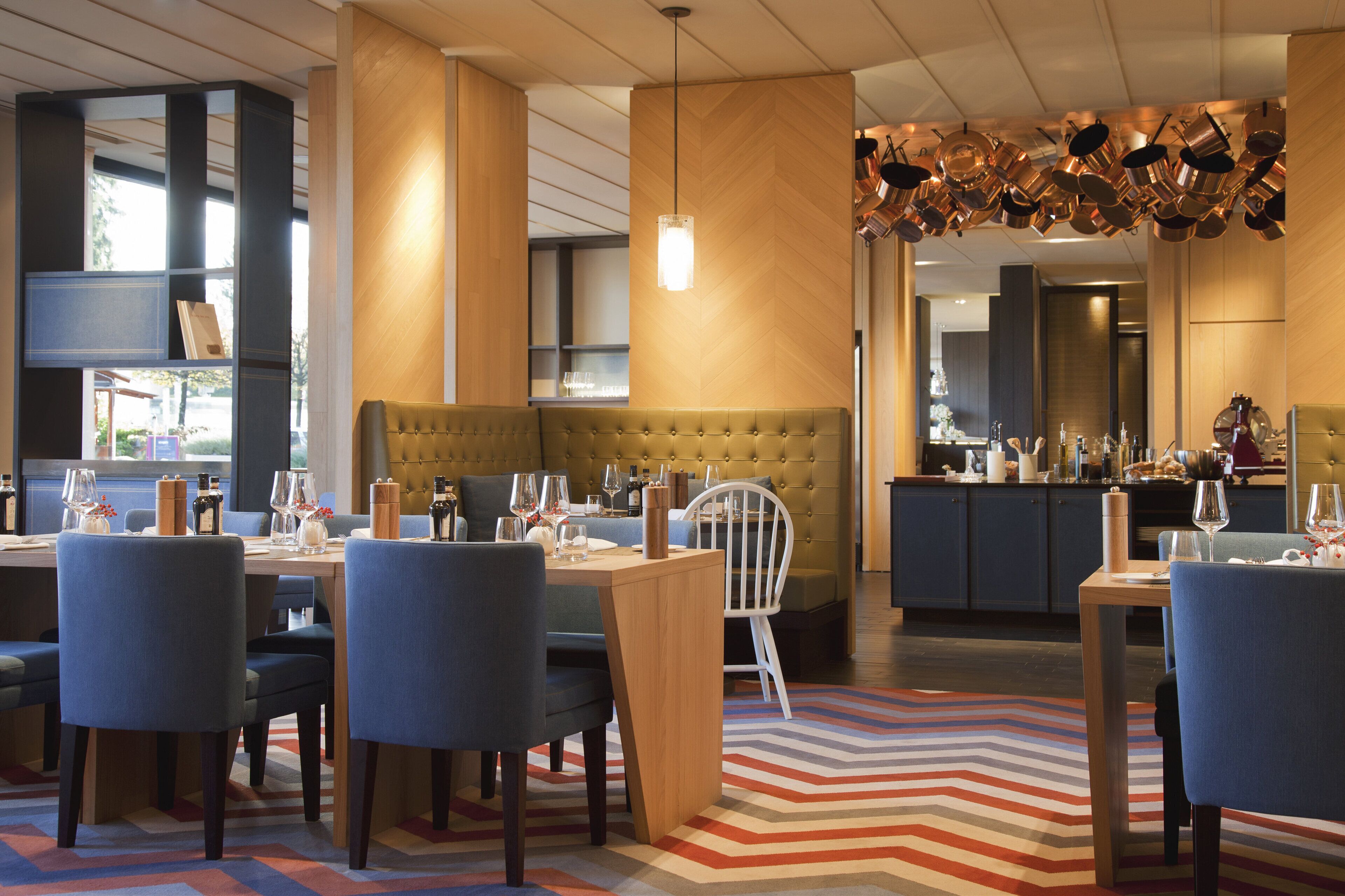 Un espace repas moderne comprenant un coin salon central, plusieurs tables et chaises.