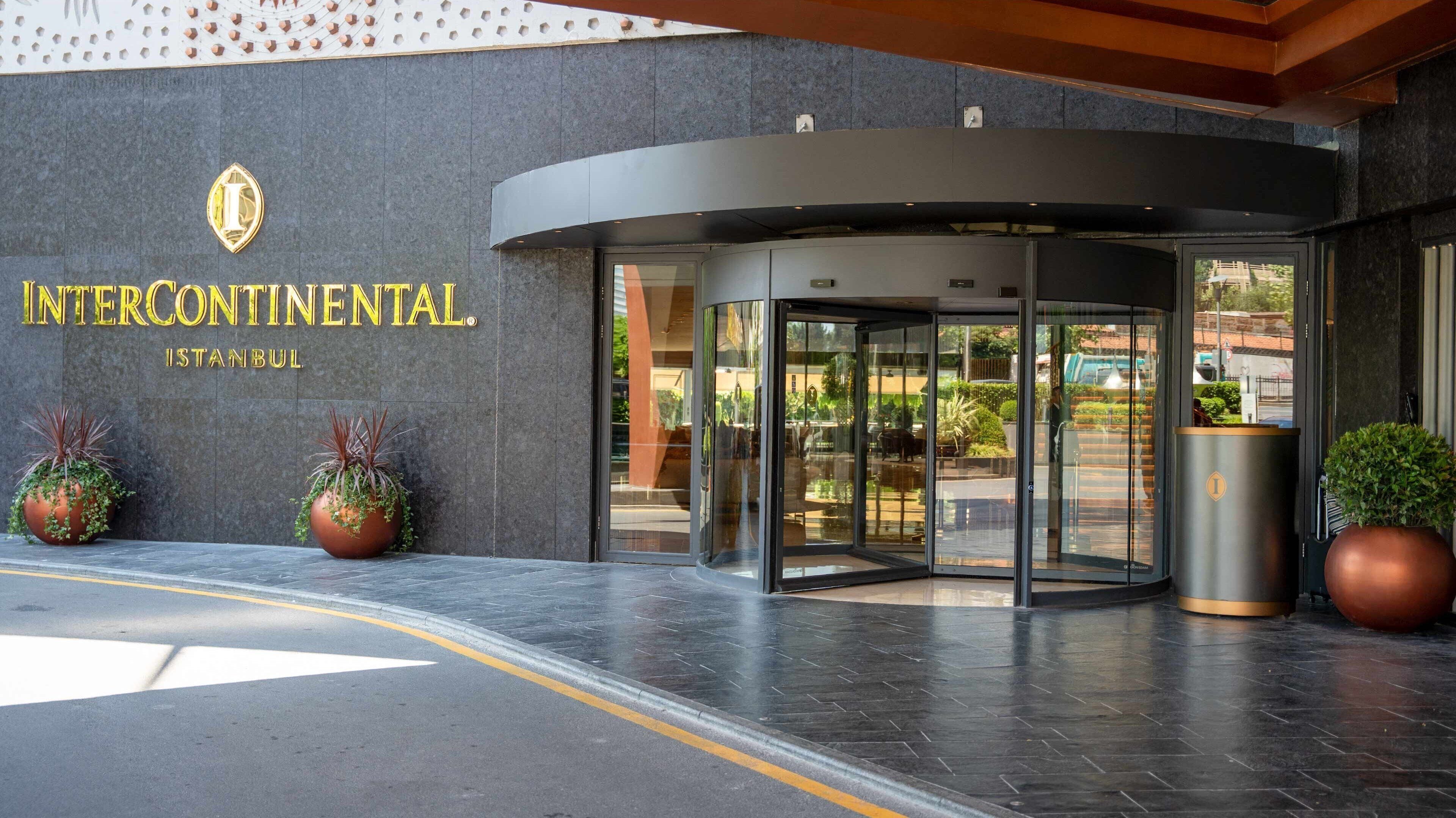 En hotellentrén med en roterande dörr, krukväxter och en skylt med texten ”InterContinental Istanbul”.