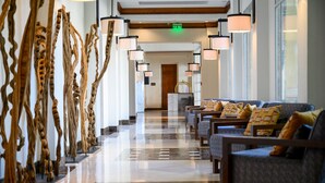 A hotel lobby with a polished marble floor, a reception desk, and a row of sofas with patterned cushions. - Real InterContinental Managua at Metrocentro Mall by IHG (Managua)