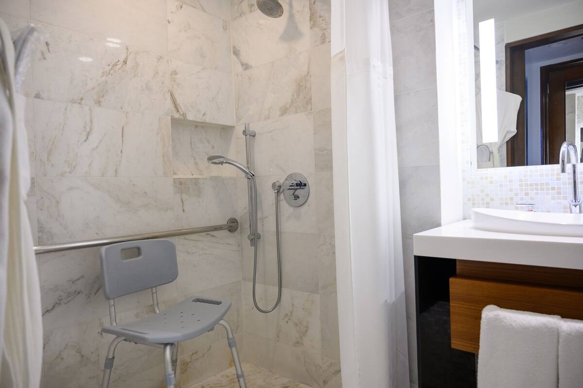 A modern bathroom with a shower, a toilet, and a sink.