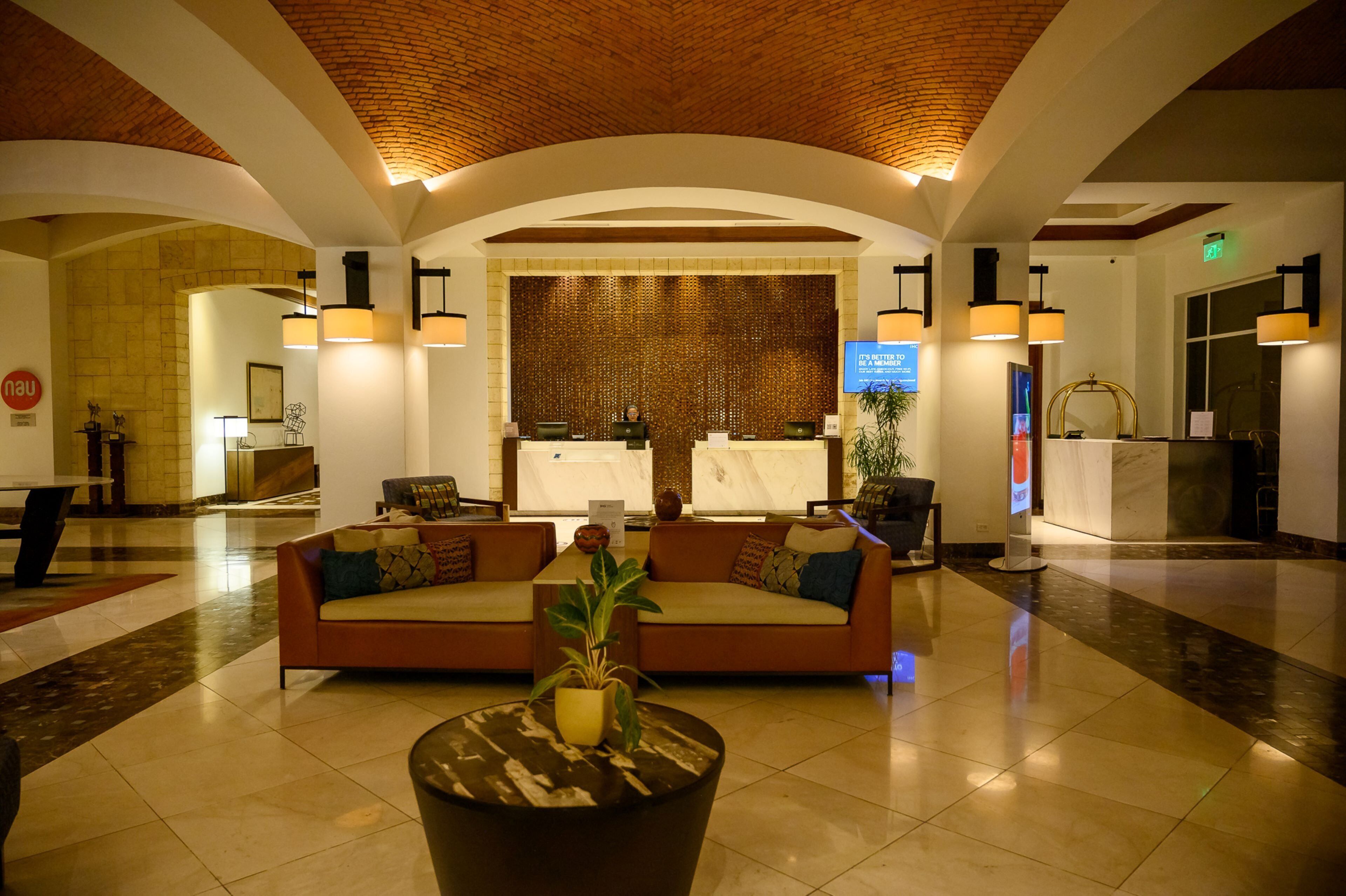 A lobby with a reception desk, a sofa, and a plant.