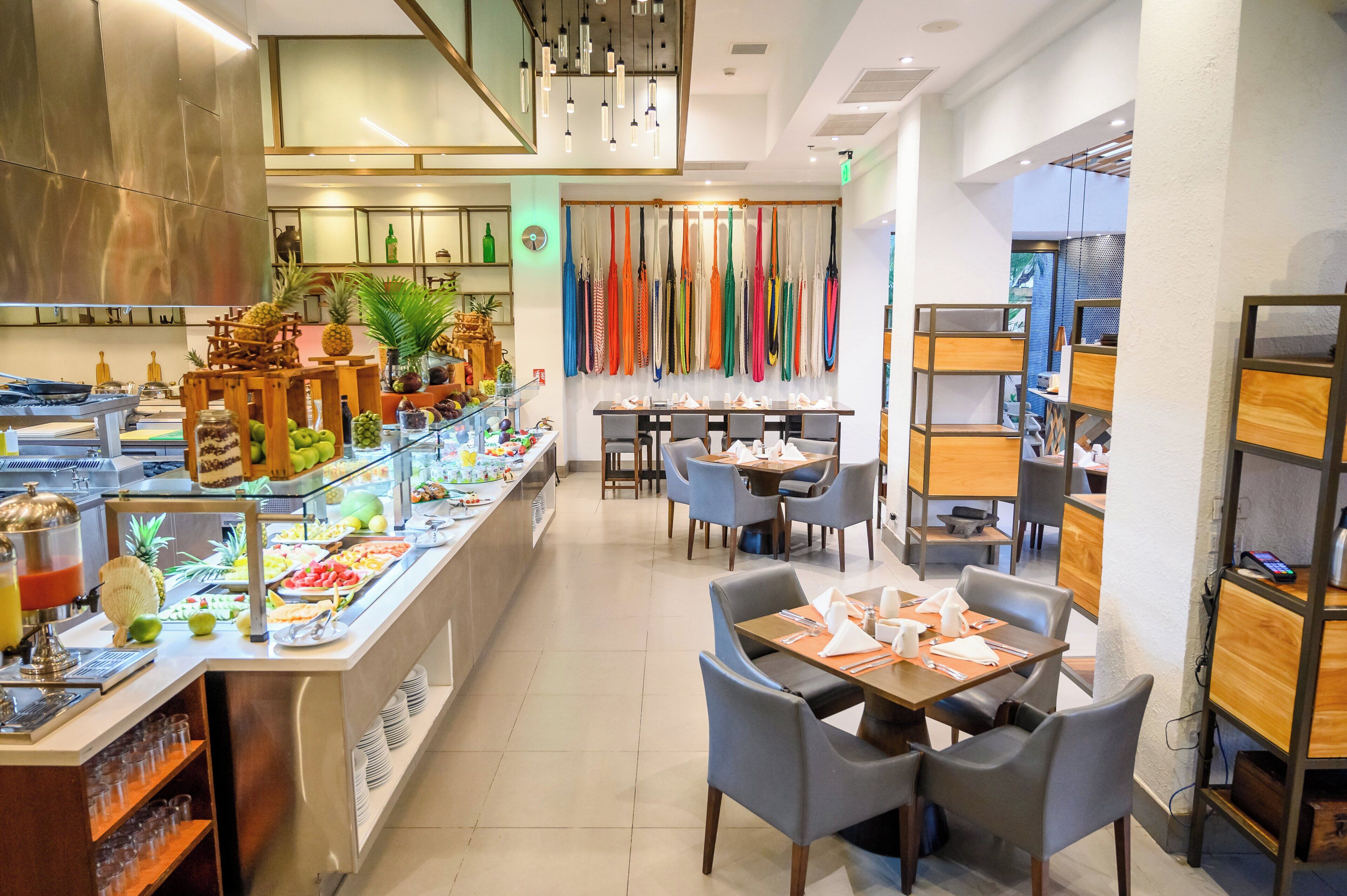 A buffet area with a variety of food items, a seating area with tables and chairs, and a display of colorful umbrellas.