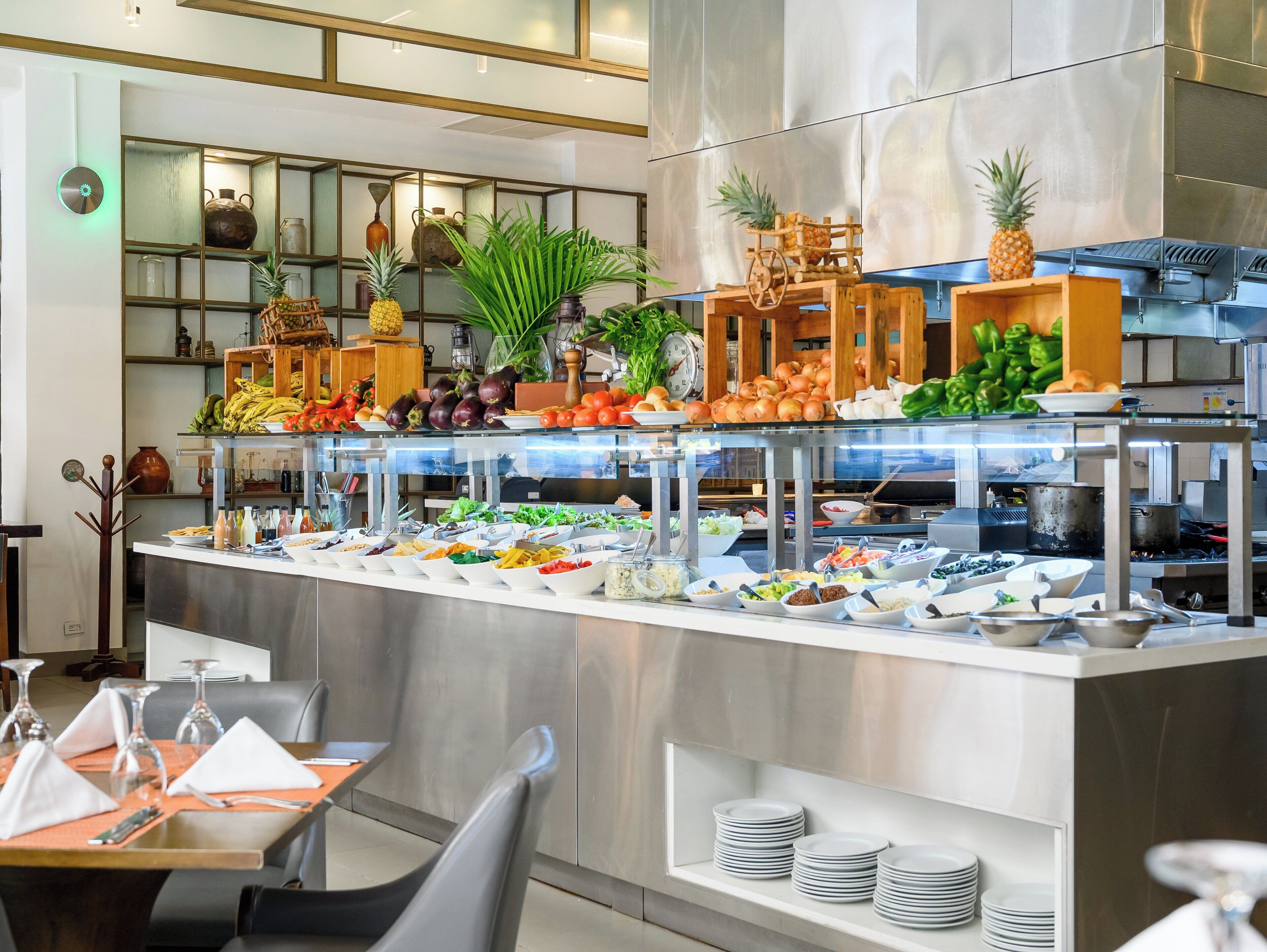 A buffet with various food items, a clock, and a plant.