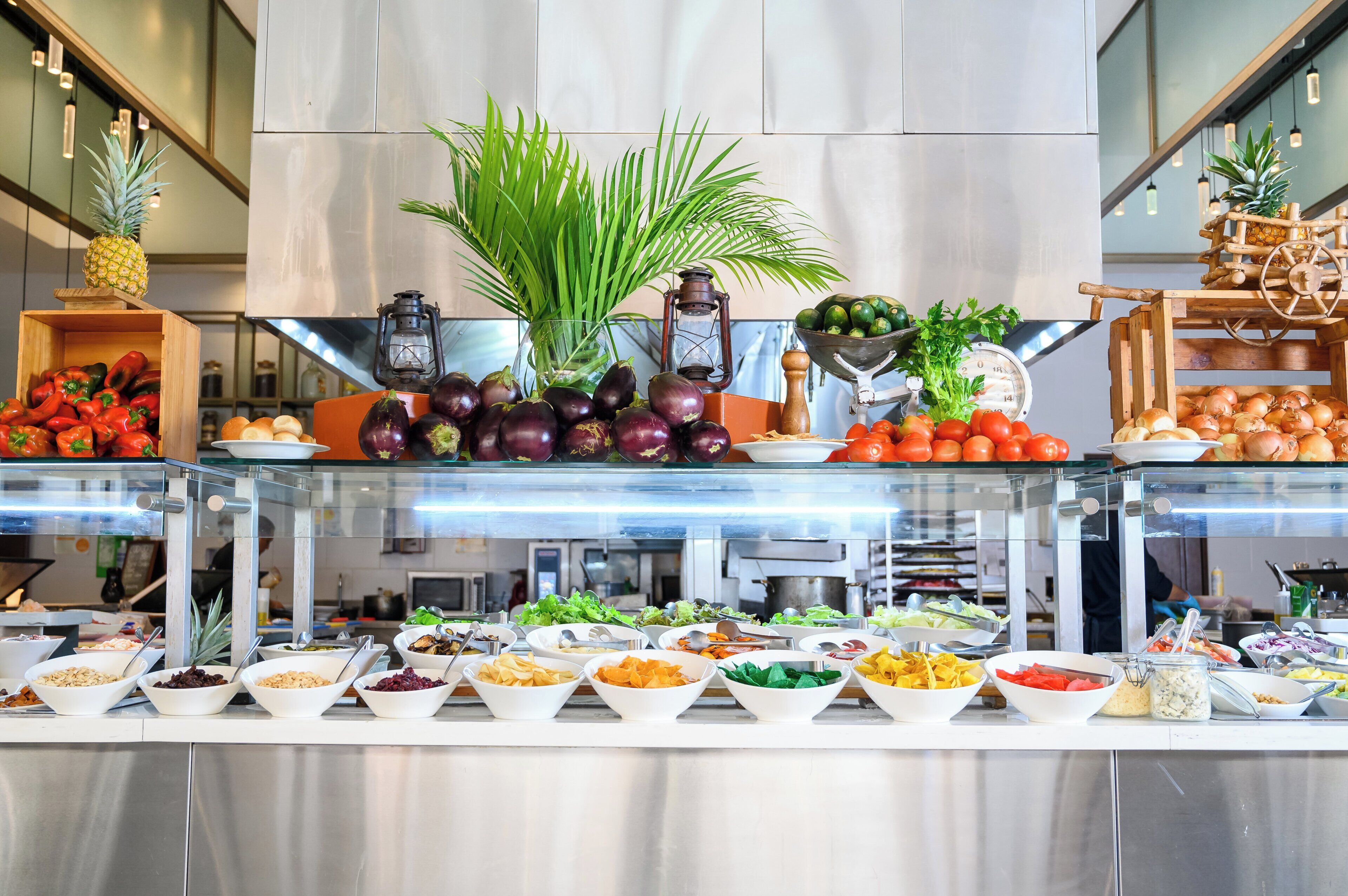 A buffet with various food items and a decorative plant.
