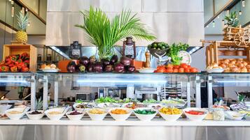 A buffet with various food items and a decorative plant.