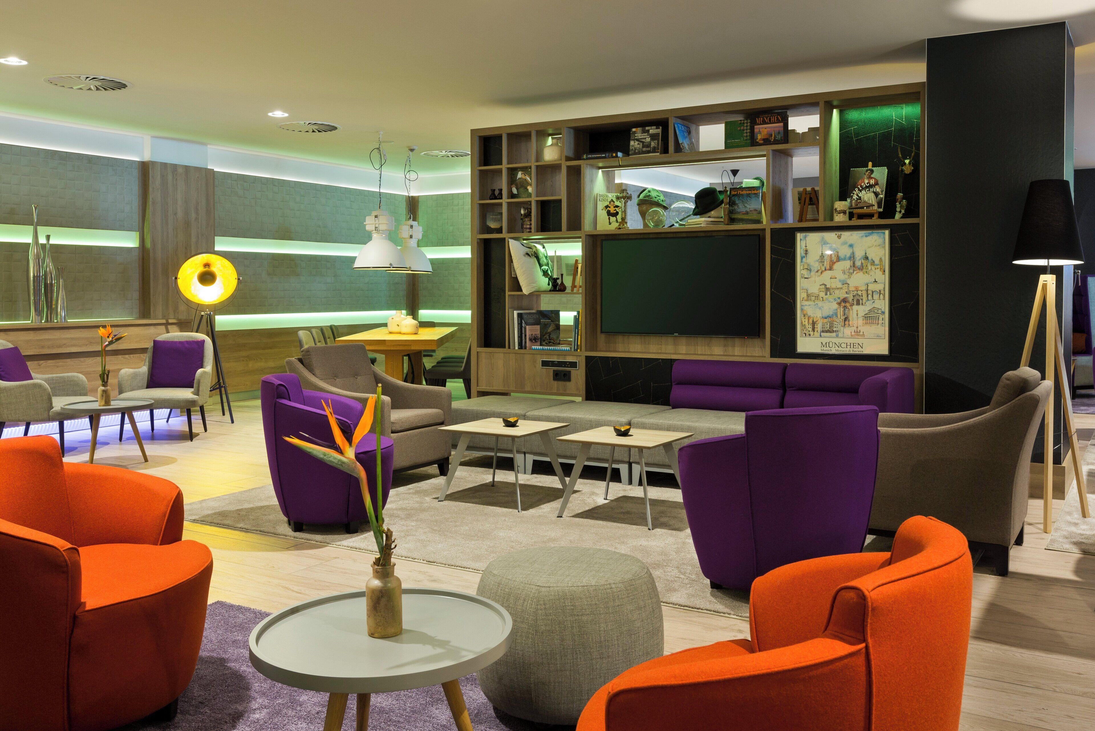 Ein stilvoller Lounge-Bereich mit Sitzgelegenheiten, einem Couchtisch und einem Bücherregal mit verschiedenen Gegenständen.