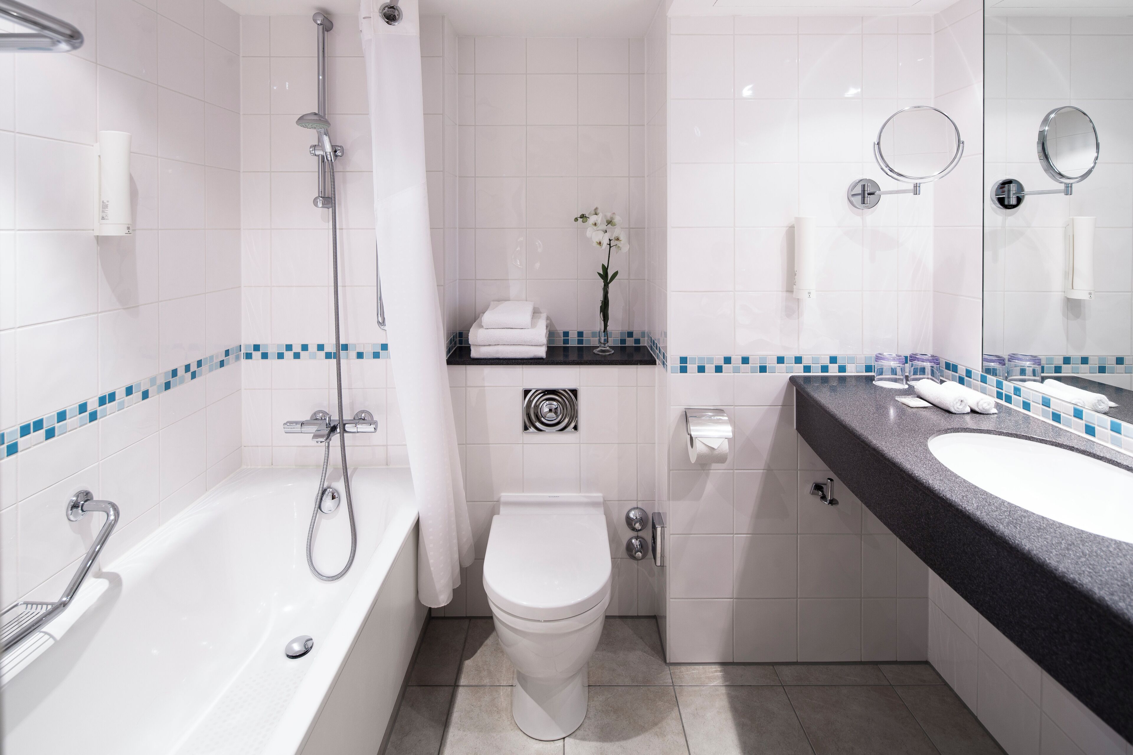 A modern bathroom with a bathtub, toilet, and sink.