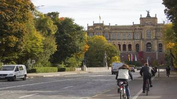 Una calle con tranvía, un edificio de arquitectura clásica y ciclistas.