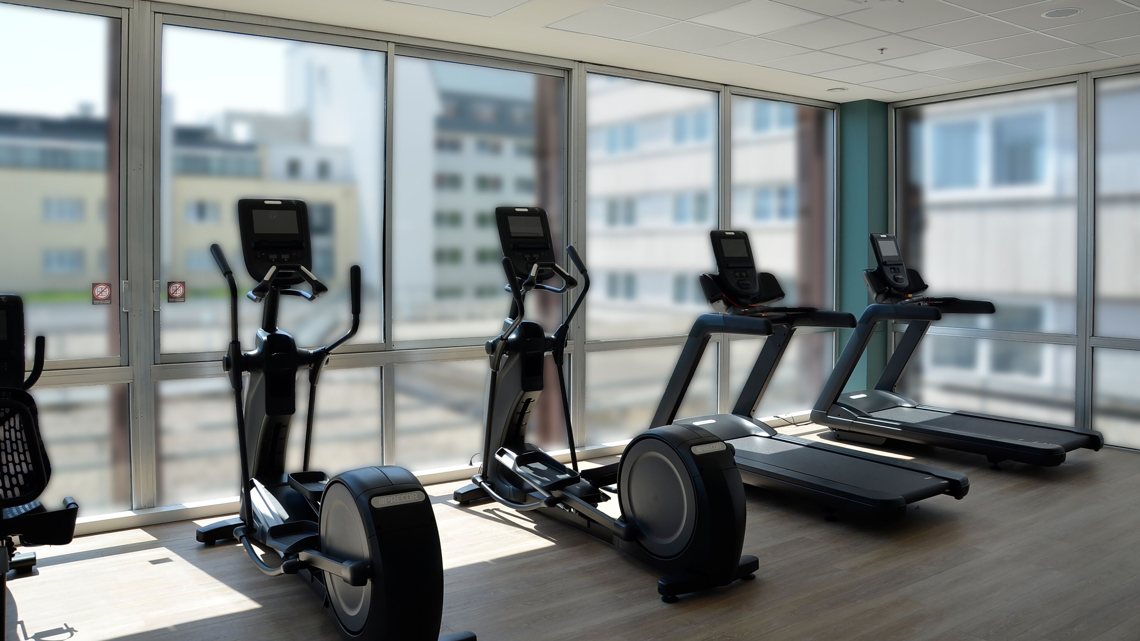 Un gimnasio moderno con bicicletas estáticas, elípticas y cintas de correr.