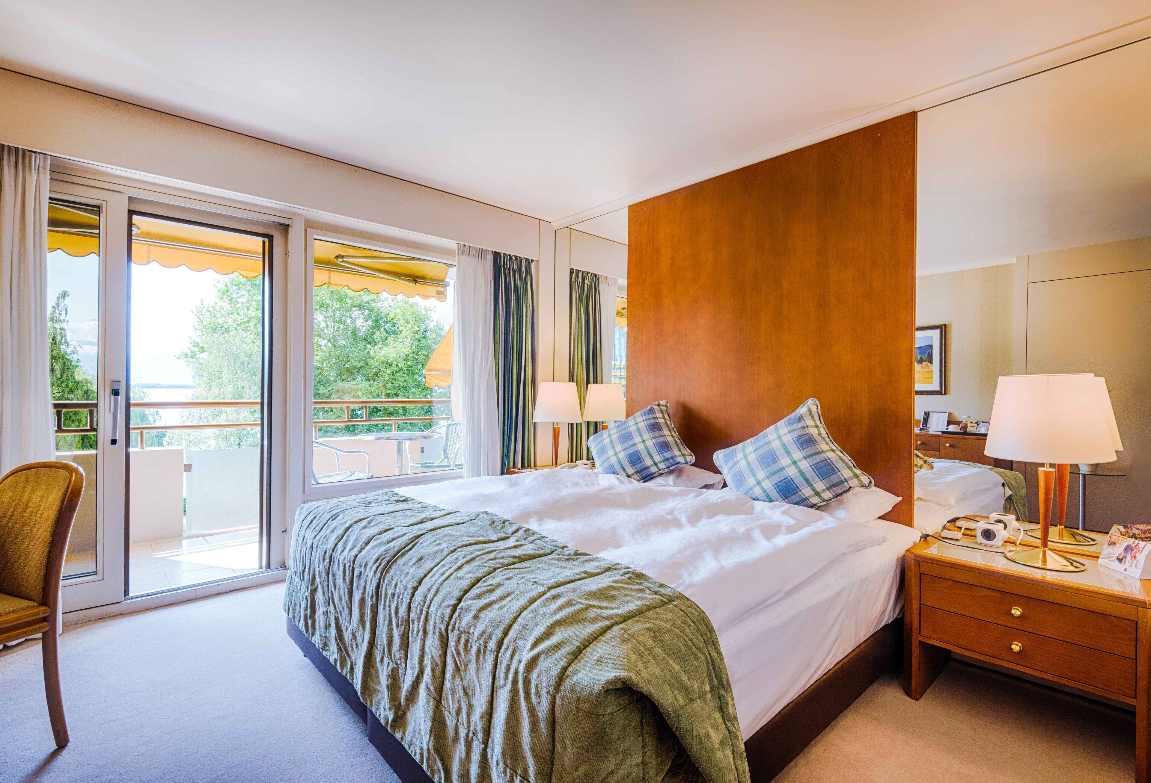 Ein Hotelzimmer mit einem großen Bett, einem Holzkopfende, einem Nachttisch mit Lampe und einem Sessel.