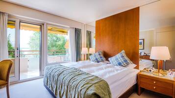 Ein Hotelzimmer mit einem großen Bett, einem Holzkopfende, einem Nachttisch mit Lampe und einem Sessel.