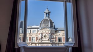 A view of a historic building with a prominent dome and clock tower, visible through a window with curtains. - Hotel Nes Amsterdam (Amsterdam)