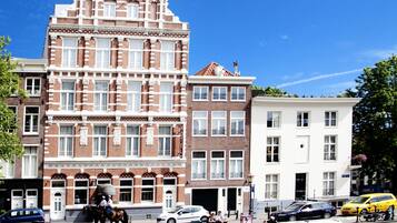 Een gracht met boten, een huifkar en gebouwen met verschillende architectuurstijlen.
