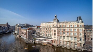 A historic building with a prominent dome and a river in the foreground.