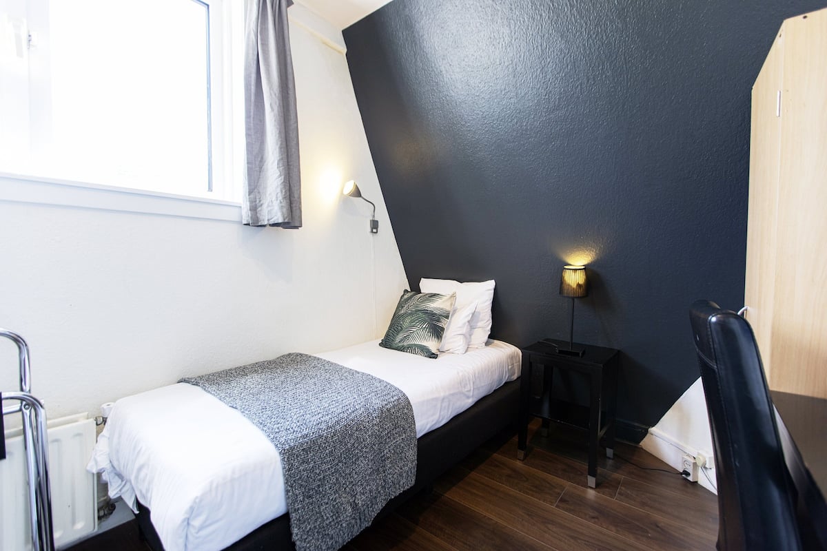 Quarto solteiro básico, 1 cama de solteiro, banheiro compartilhado | Cortinas blackout, ferros/tábuas de passar roupa, Wi-Fi de cortesia