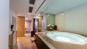 A modern bathroom with a glass-enclosed jacuzzi, a wooden bench, and a towel rack. - Aparthotel Atenea Valles (Granollers)