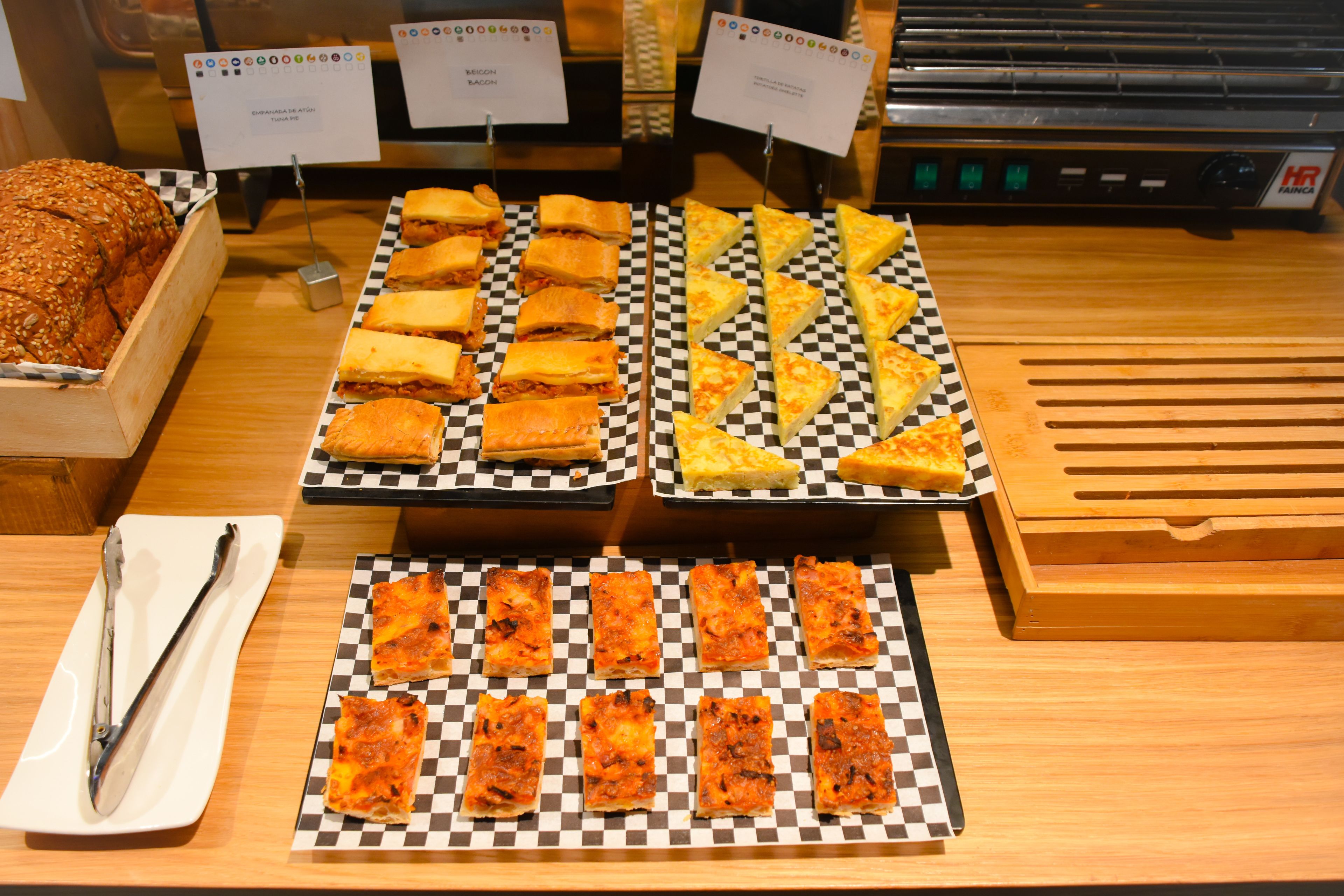 A buffet with various types of sandwiches and pizzas.