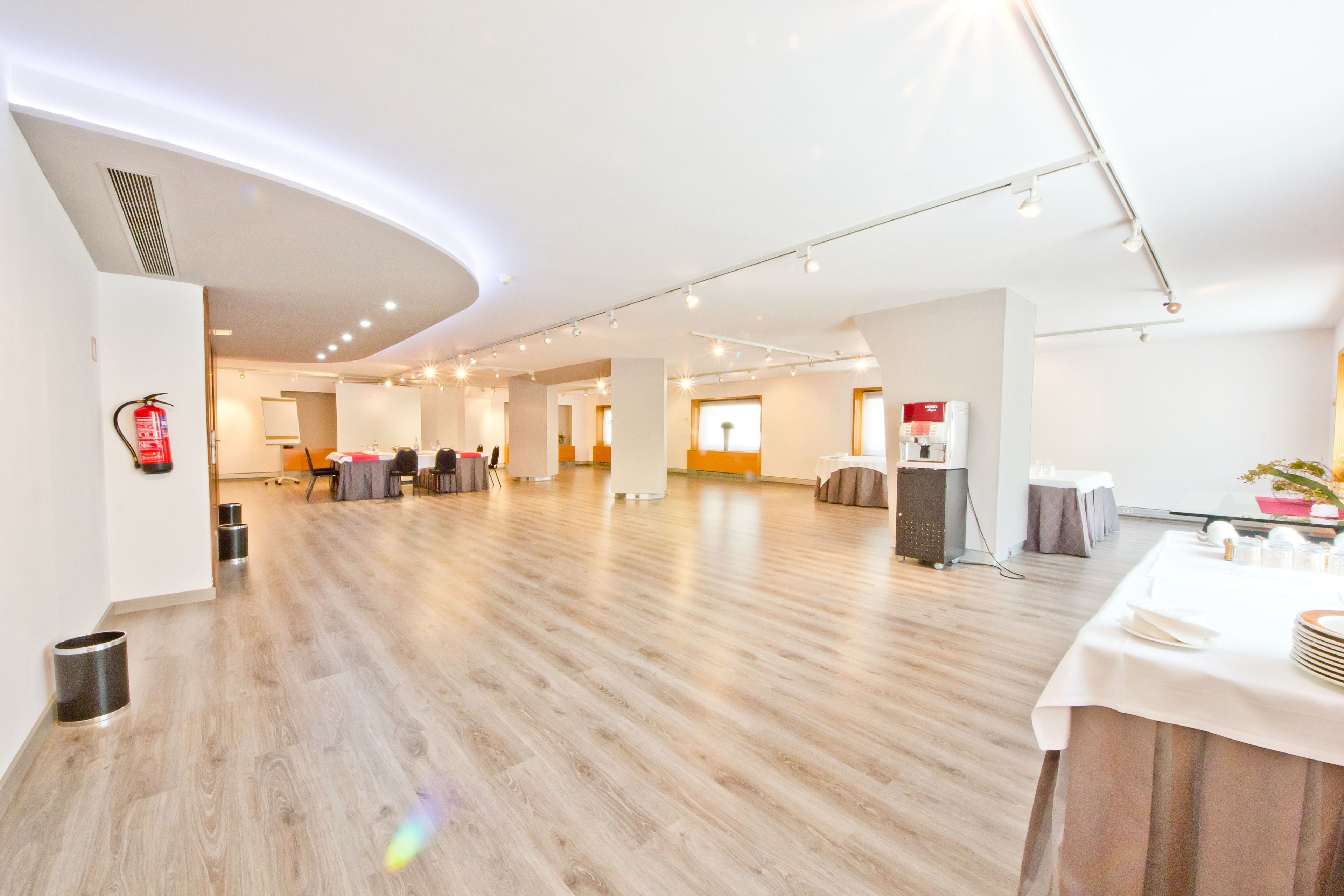 Eine geräumige Hotelhalle mit Holzboden, einer Rezeption und einer Sitzecke.