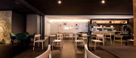 A modern restaurant with a bar area, multiple seating options, and a clean, contemporary design.