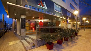 A hotel entrance with a modern design, featuring a prominent sign, a staircase, and potted plants. - Aparthotel Atenea Valles (Granollers)
