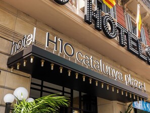 Un cartel de hotel con el nombre 'Hotel H10 Cataluny Plaza'.