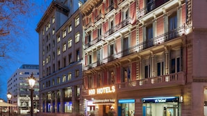 Un edificio storico con balconi decorati e un cartello di hotel ben visibile.