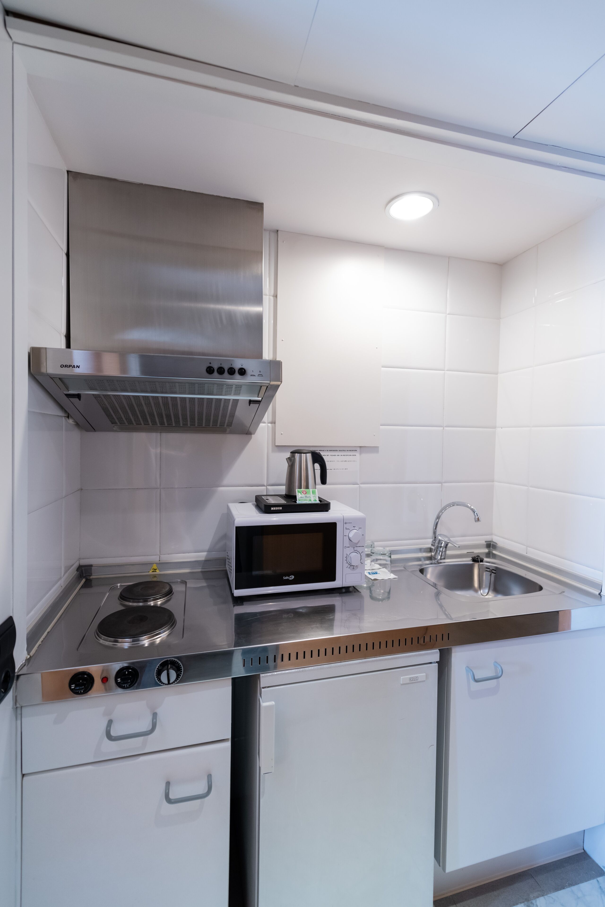 A modern kitchen with stainless steel appliances, a microwave, and a sink.