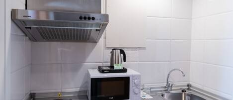 A modern kitchen with stainless steel appliances, a microwave, and a sink.