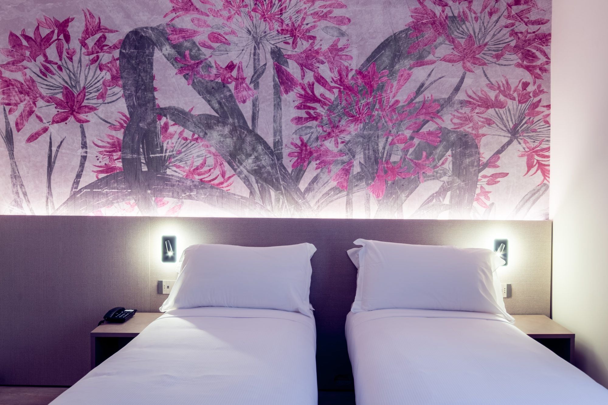 Ein Hotelzimmer mit Bett, Nachttischen und einer Wandleuchte.
