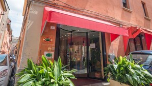 A building with a red awning, a sign reading "CENTRALE," and a door with a glass entrance. There are potted plants in front. - Hotel Centrale (Bologna)