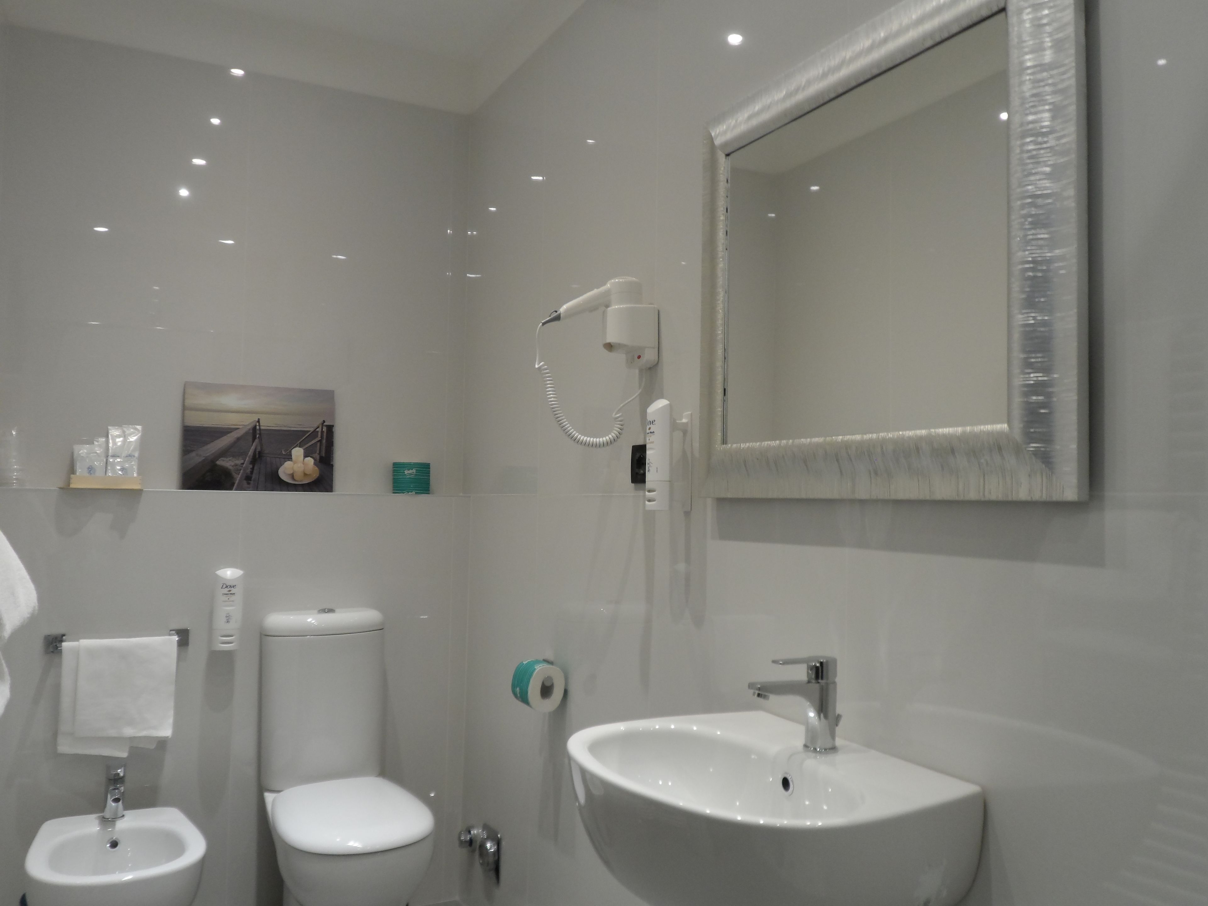 Een moderne badkamer met toilet, bidet en wastafel.