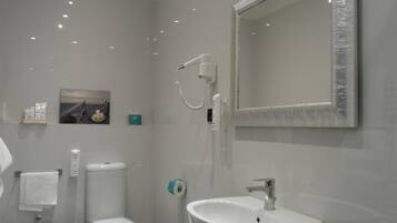 Een moderne badkamer met toilet, bidet en wastafel.