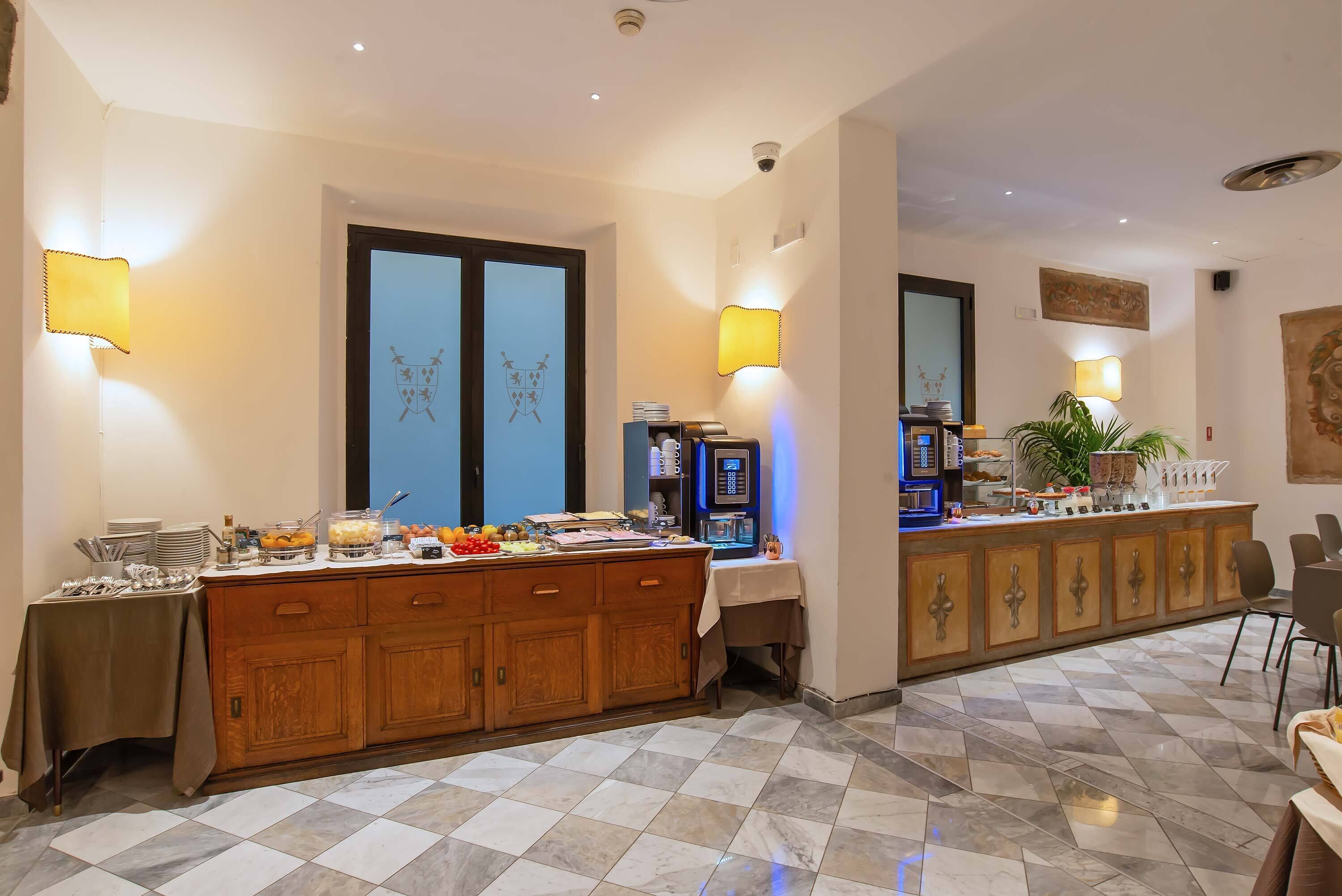Ein Hotel-Frühstücksbereich mit einem Buffet, einer Kaffeemaschine und einer Sitzecke mit Stühlen.