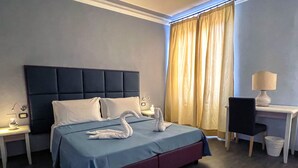 A hotel room with a bed, a desk, a chair, and a window with curtains. - Hotel Gioia (Florence)