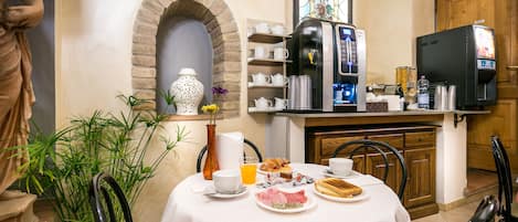 Una mesa de desayuno servida con platos, tazas y una cafetera.
